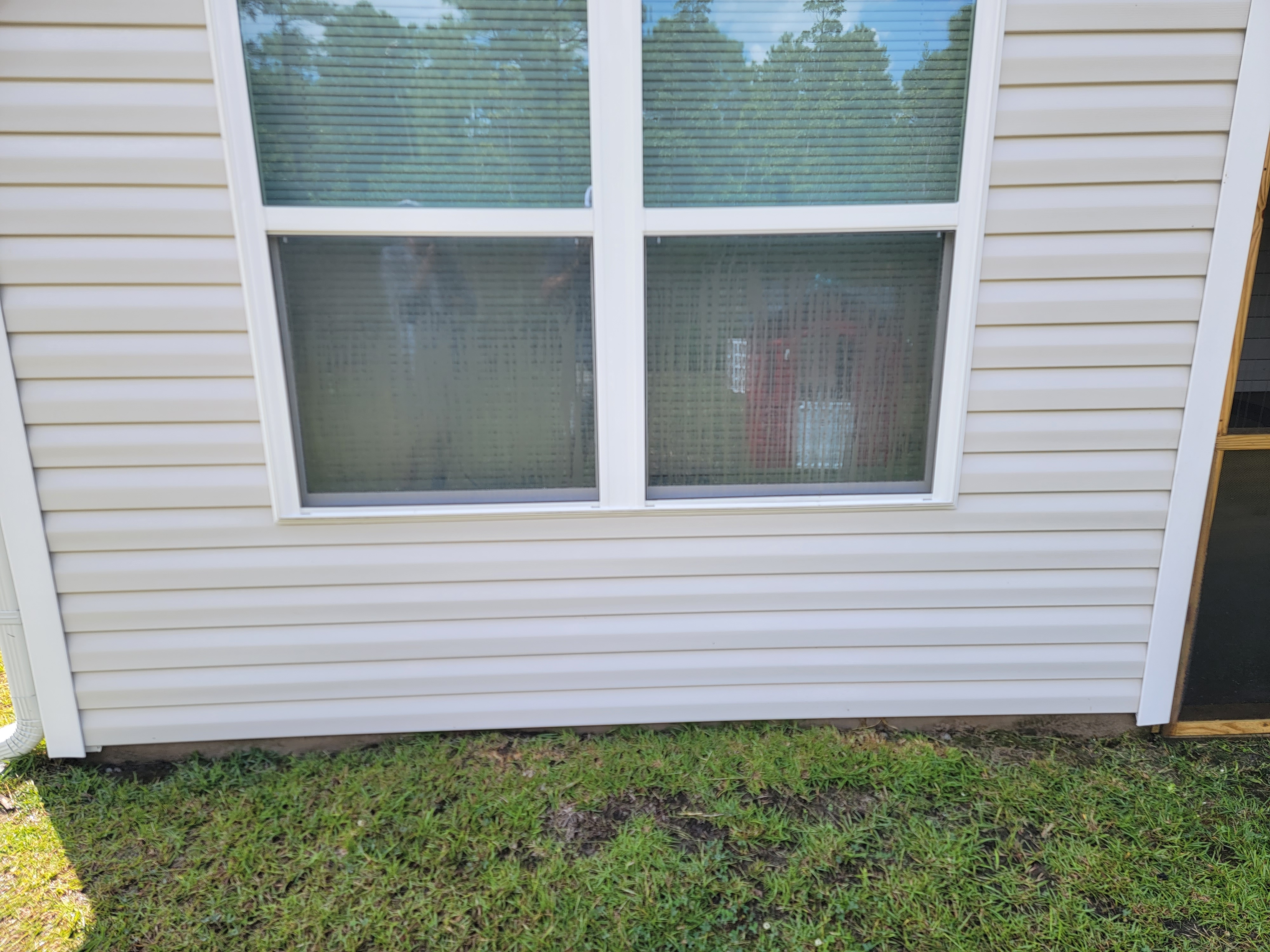 After house wash: white residential siding refreshed below a double window
