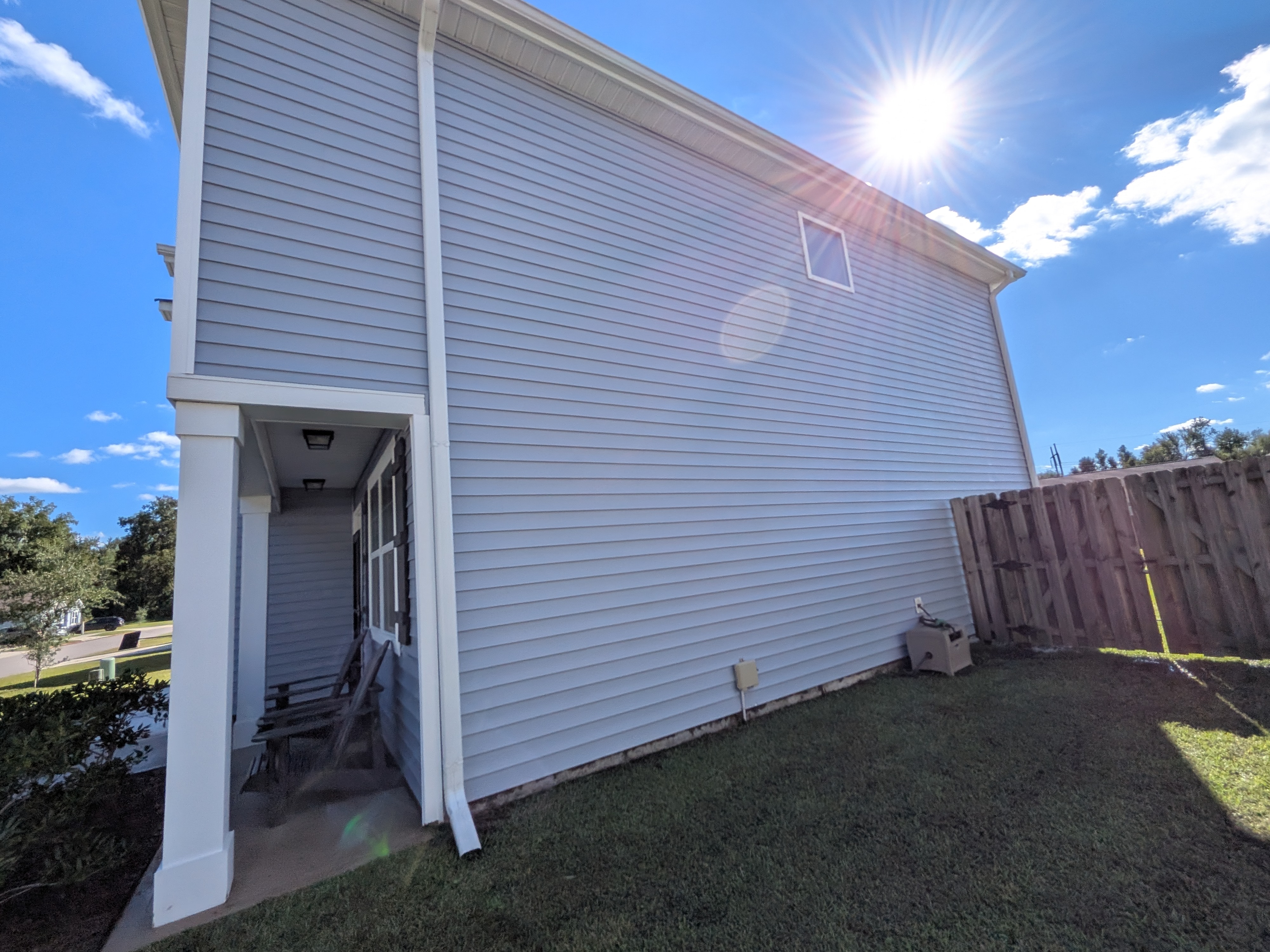 After house washing: clean light-colored siding shown in a wide exterior view